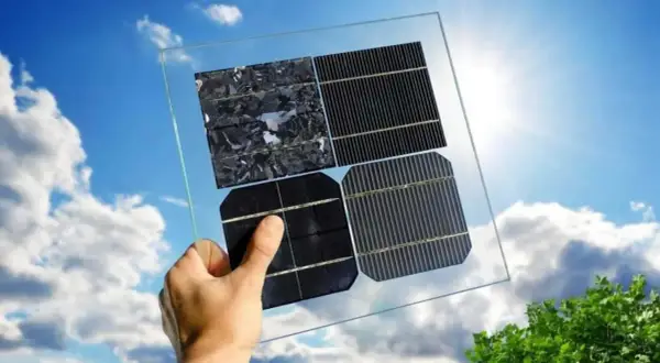 Mano sostiene panel solar con diferentes celdas. ¡Aprovecha la bonificación IBI para placas solares en Castilla-La Mancha!