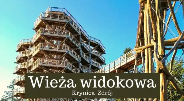 Drewniana wieża widokowa w Krynicy-Zdroju wznosi się ku błękitnemu niebu, oferując wspaniałe widoki na okolicę.