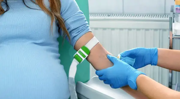 Gravid kvinna får blodprov taget, en del av den vanliga vården som kan komplettera en kub ultraljud.