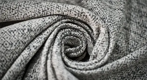 Graues, gemustertes Polyester-Material, kunstvoll zu einer Spirale gedreht.