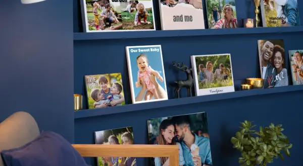 Schöne Fotowand Ideen mit Familienfotos auf blauen Regalen. Ein Baby, Kinder und Paare lächeln von den Bildern.
