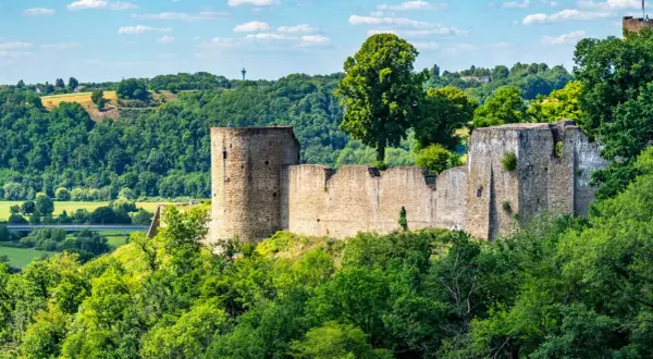 Ruinen der Burg Blankenberg thronen auf einem Hügel, umgeben von üppigem Grün. Ein historisches Zeugnis der Stadt Blankenberg.