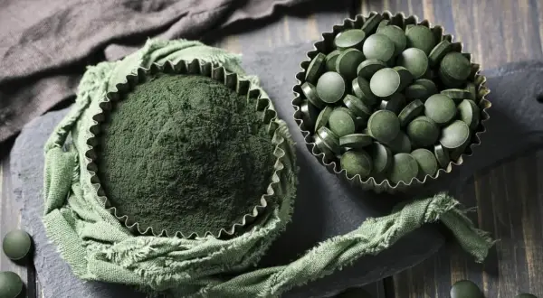 Proszek i tabletki z chlorelli. Choć suplementacja jest popularna, warto znać potencjalne chlorella skutki uboczne.