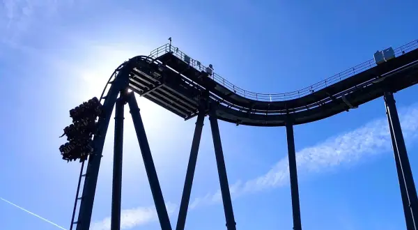 Wagonik z pasażerami na szczycie najwyższego rollercoastera na świecie, tuż przed zjazdem.
