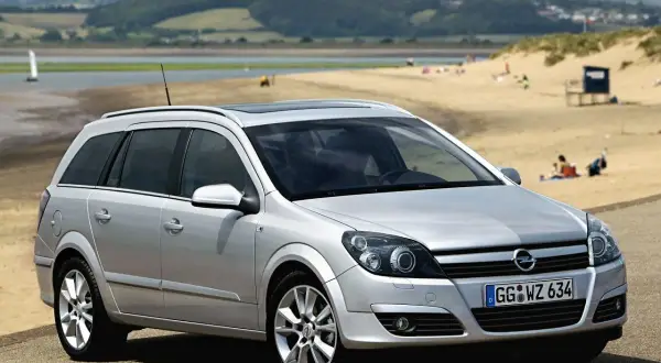 Srebrna astra 2 kombi na tle plaży i morza.