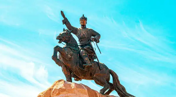 Statue équestre d'un guerrier, symbole de la descendance de Gengis Khan, sous un ciel bleu éclatant.