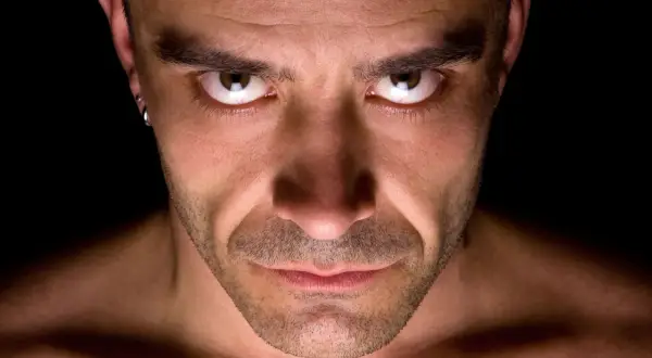 Intens blick från en man med örhänge. Kanske resultatet av ett psykopat test?