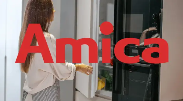 Kobieta otwiera lodówkę Amica, polską firmę znaną z produkcji sprzętu AGD.