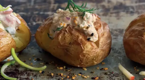 En gyllene bakad potatis med en krämig fyllning av tonfisk och örter, toppad med dill. En läcker och mättande rätt.