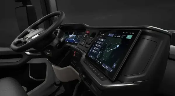 Vue du scania interieur cabine, avec volant, écrans tactiles affichant navigation et informations, et tableau de bord moderne.