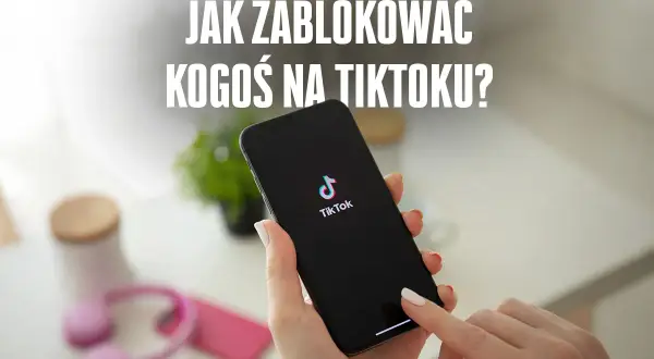 Dłoń trzyma smartfon z logo TikToka. Na ekranie telefonu widoczny jest napis "JAK ZABLOKOWAĆ KOGOŚ NA TIKTOKU?".