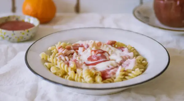 Fusilli z kremowym sosem i kawałkami owoców. Pyszny makaron na słodko, idealny na deser.