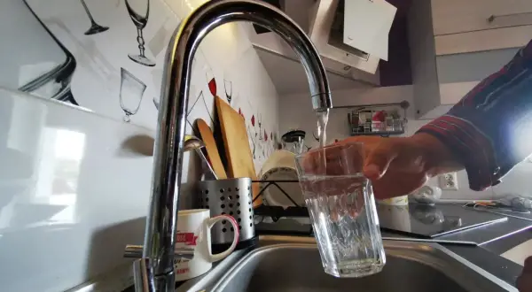 Nalewanie wody z kranu do szklanki. Woda ta może zawierać chlor, który jest często dodawany w celu dezynfekcji.