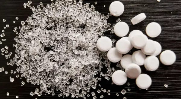 Sorbitol co to? Porównanie kryształków cukru i tabletek słodzika.