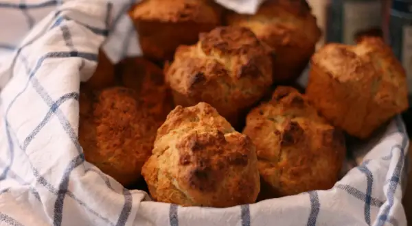 En korg med nybakade scones, perfekt för fika. Sconesdegen har fått en gyllene färg.