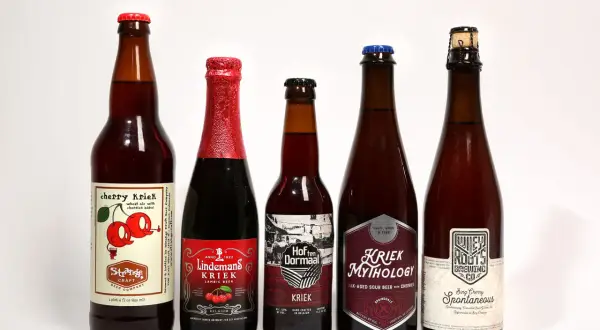 Pięć butelek belgijskiego piwa wiśniowego, w tym Kriek Mythology i Lindemans Kriek.