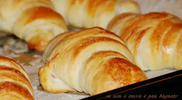 Cornetti con lievito madre dorati e fragranti, appena sfornati, pronti per una colazione perfetta.