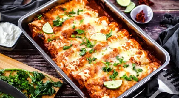Herzhafte Enchiladas im Ofen, überbacken mit Käse und garniert mit Limettenspalten und Koriander. Ein tolles Enchiladas Rezept für jeden Anlass.