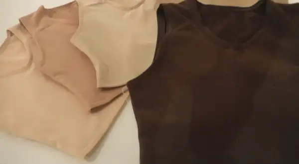 Kilka bezrękawnikowych bawełnianych t-shirtów w odcieniach beżu i brązu.