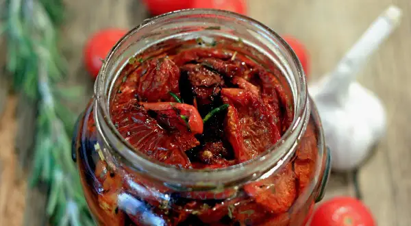 Pomodori secchi sott'olio, una ricetta pugliese che profuma di sole e tradizione. Un vasetto pieno di sapore, con aglio e rosmarino.