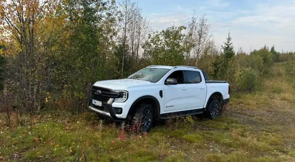 Vit Ford Ranger Wildtrak står parkerad vid en skogsväg. Kanske ett litet problem med terrängen?