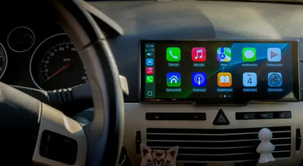 CarPlay co to? Ekran multimedialny w samochodzie z ikonami: Telefon, Muzyka, Mapy, Wiadomości, Samochód, Podcasty, Audiobooki, Kalendarz, Ustawienia.