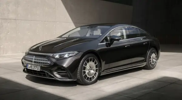 Elegancki, czarny Mercedes-Benz EQS, lśniący w słońcu, z charakterystycznym grillem i felgami.