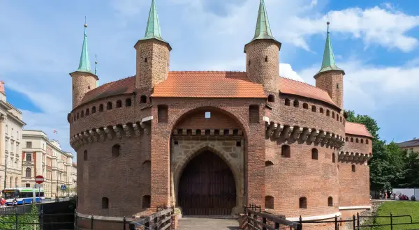 Barbakan w Krakowie, jedna z głównych kraków atrakcje, zaprasza do zwiedzania. Drewniany most prowadzi do zabytkowej budowli.