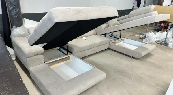 Sofa z systemem rozkładania Delfin, z otwartymi schowkami pod siedziskami.
