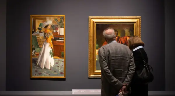 Para zwiedza muzeum sztuk użytkowych, podziwiając obrazy.