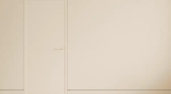 Puerta blanca minimalista con manija discreta y un rodapié enrasado que se funde con la pared, creando un espacio limpio y moderno.