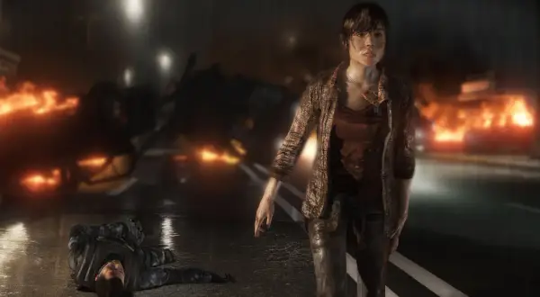 Jodie Holmes stoi na tle płonących samochodów, obok leży nieprzytomny żołnierz. To scena z gry Beyond Two Souls, która pokazuje intensywny czas gry.