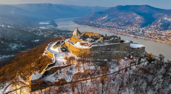Zimowy krajobraz z górującym nad Dunajem **Wyszehrad**, ośnieżone ruiny zamku i malownicza dolina.