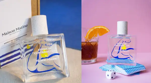 Perfumy Maison Matine Esprit de Contradiction w szklanej butelce z niebieskim wzorem. Obok kostka do gry i talia kart.