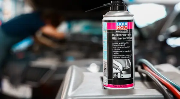Puszka preparatu do czyszczenia wtryskiwaczy diesel marki Liqui Moly na tle silnika samochodu.