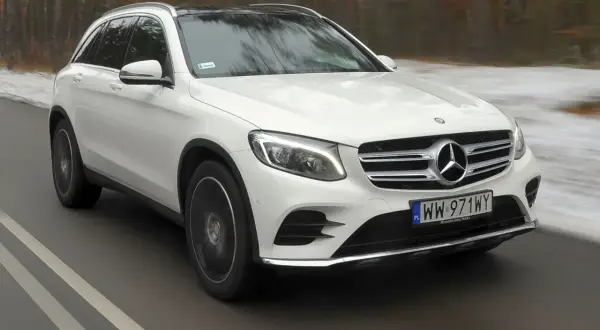 Biały Mercedes-Benz GLC w ruchu drogowym. Wiele osób szuka takich aut, sprawdzając mercedes glc opinie.