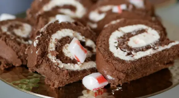 Chokladrulltårta med fluffig grädde och bitar av godis. En härlig dessert som passar perfekt till fikat.
