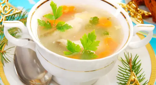 Aromatyczna zupa rybna przepis prosty, podana w eleganckiej miseczce, ozdobiona gałązkami choinki i złotymi gwiazdkami.