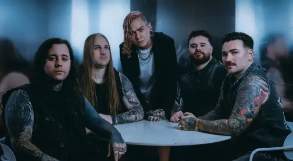 Zespół Lorna Shore Polska przy okrągłym stole, z tatuażami i w mrocznym klimacie.