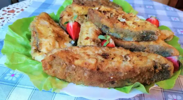 Chrupiący halibut smażony, podany na liściach sałaty z kawałkami truskawek. Pyszne danie!