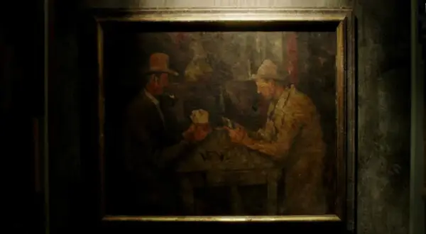 Obraz: dwaj mężczyźni w kapeluszach grający w karty przy stole. Jeden z nich pali fajkę.