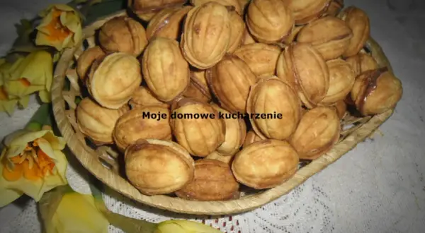 Koszyczek pełen domowych ciasteczek orzeszków z kremem do orzeszków z mlekiem w proszku, ozdobiony żółtymi narcyzami.