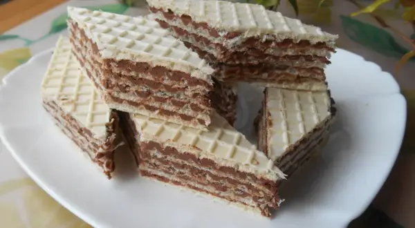 Kawałki wafli z kremem czekoladowym, przypominające smakiem wafle z mlekiem w proszku, ułożone na białym talerzu.