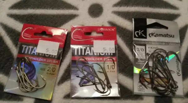 Trzy opakowania haczyków wędkarskich. Dwa z napisem "TITANIUM", jeden z "Kamatsu". Idealne, by złowić karasia.