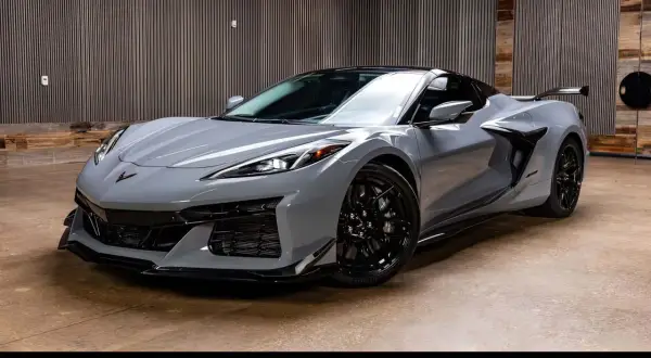 Szary Chevrolet Corvette C8 z czarnymi felgami i spojlerem, gotowy do jazdy.