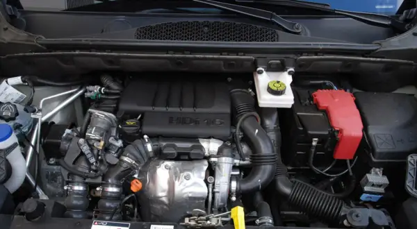 Silnik 1.6 HDI w Berlingo. Widoczny blok silnika, turbosprężarka, przewody i akumulator.