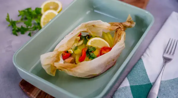 Salmone al cartoccio con patate, pomodorini e limone, pronto per essere infornato.