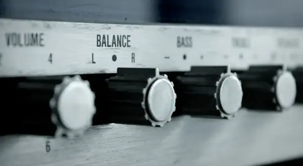 Nahaufnahme von Reglern eines Verstärkers: VOLUME, BALANCE, BASS. Ein Drehknopf für den gain regler ist gut sichtbar.