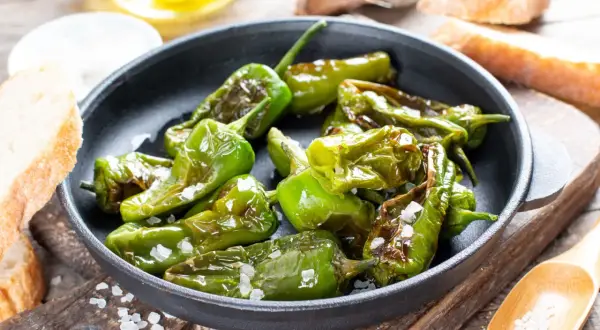 Friggitelli in padella, cotti al punto giusto e cosparsi di sale grosso, pronti per essere gustati con pane fresco.