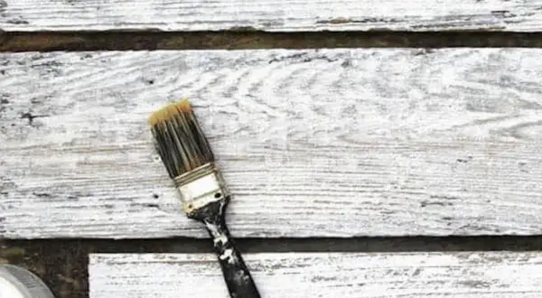 Pennello sporco su assi di legno verniciato con cementite, effetto shabby chic.
